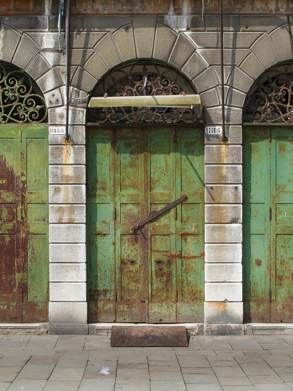 Old doors with green-brown patina in Venice, Italy